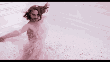 a man in a bathtub covered in pink petals with the word reduce app visible in the corner