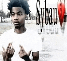 a young man is standing in front of a sign that says sybau .