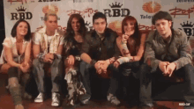a group of people are posing for a picture in front of a rbd sign