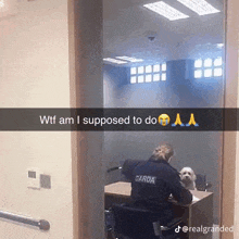 a woman in a garda uniform sitting at a desk with a dog