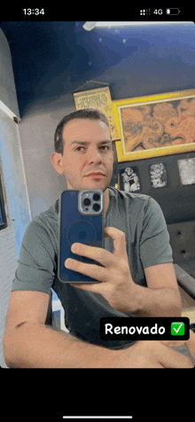 a man is taking a picture of himself in a mirror with the time of 13:34
