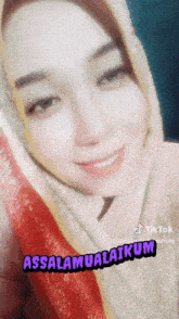 a woman wearing a hijab is smiling with the words assalamualaikum written below her