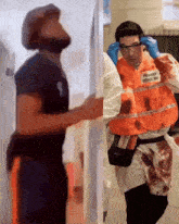 a man wearing an orange vest that says primary trace md on it