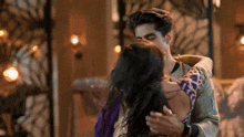 a man and a woman are hugging each other and kissing in a room .