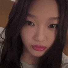 a close up of a woman 's face with long hair and pink lips