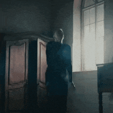 a person is standing in front of a window with their arms outstretched