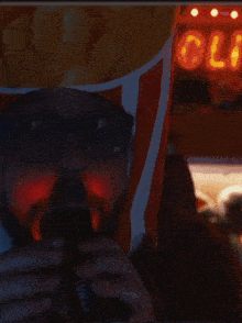 a man wearing a popcorn hat is singing into a microphone in front of a sign that says old