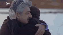 a man and a woman hugging with a hd logo behind them