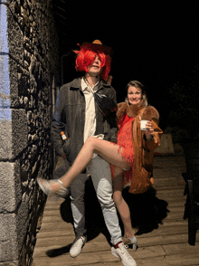 a man in a red wig holds a woman in a fur coat