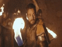 a man with a beard is holding a torch in his hand .