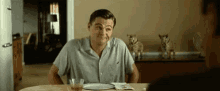 a man is sitting at a table with a plate of food .