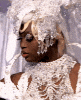 a close up of a woman wearing a white dress and a pearl necklace