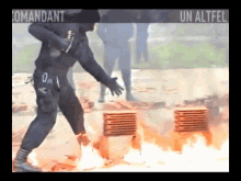 a man in a black uniform is standing in front of a fire and a sign that says " un altfel "