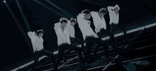 a group of men are standing on top of a stage .