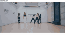 a group of women are dancing in a room that says wne entertainment on the wall