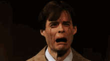 a man in a suit and tie is crying with tears coming out of his eyes .