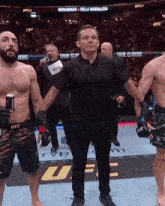 a referee is holding the hand of a fighter in a ufc fight .