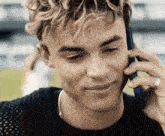 a young man is talking on a cell phone