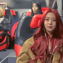 a woman with red hair is sitting on a bus with a sign that says no off in the background