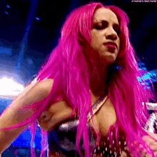 a woman with pink hair is standing in a ring .