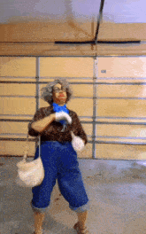 a woman in overalls is standing in front of a garage door holding a purse