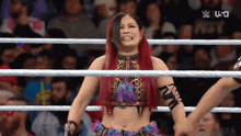 a woman with red hair is in a wrestling ring with us written on the screen
