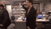 a man in a suit is pointing at something