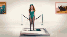 a woman in a green playboy bunny costume is standing on a bed