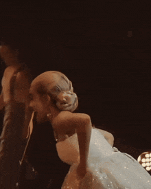 a woman in a white dress is dancing with a man