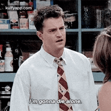 a man in a white shirt and tie is talking to a woman in a store .