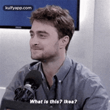 a man with a beard is talking into a microphone and asking what is this ? ikea ?