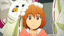 a girl is being petted by a cat with orange eyes