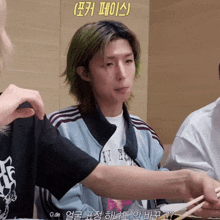 a man with green hair is holding chopsticks and wearing a shirt that says ' o.de ' on it