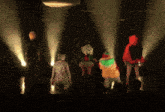 a group of people are dancing on a stage with spotlights