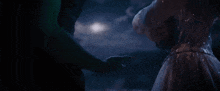 a man and woman holding hands in the dark