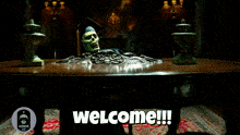 a skeleton wearing a graduation cap and gown sits at a table with the words welcome written on the bottom