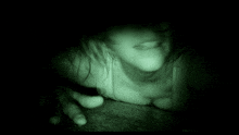 a close up of a person 's face in the dark with a green light coming out of their mouth .