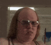 a woman wearing glasses and a tank top is looking up at something .