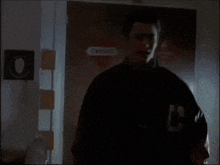 a man is standing in front of a door that has a danger sign on it