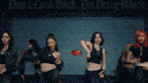 a group of women are dancing in front of a sign that says " do n't look back "