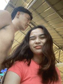 a shirtless man and a woman are posing for a photo
