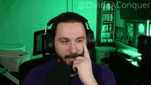 a man with a beard wearing headphones and a purple shirt