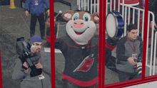 a mascot for the carolina hurricanes stands in front of a cameraman