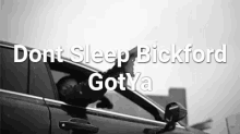 a black and white photo of a man driving a car with the words " dont sleep bickford got ya " on the bottom