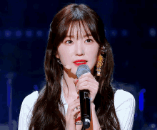 a woman holding a microphone with a sticker on it that says ' i love you ' on it