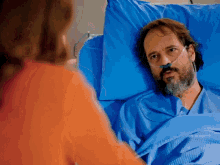 a man laying in a hospital bed with an oxygen mask on his face