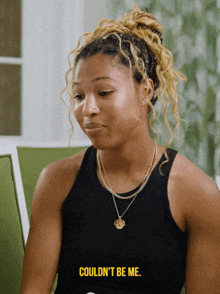 a woman in a black tank top says could n't be me in yellow letters