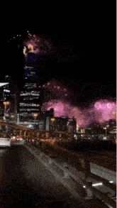 fireworks are displayed in the night sky over a bridge