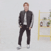 a man in a black jacket and black pants is dancing