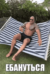 the rock is sitting in a hammock holding a can of coke .
